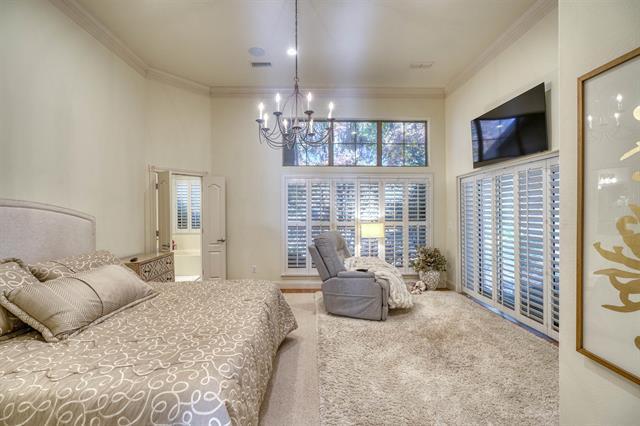 104 Mason Ct, Horseshoe Bay, TX 78657 - bedroom featuring ornamental molding, a chandelier, a high ceiling, carpet flooring, and multiple windows