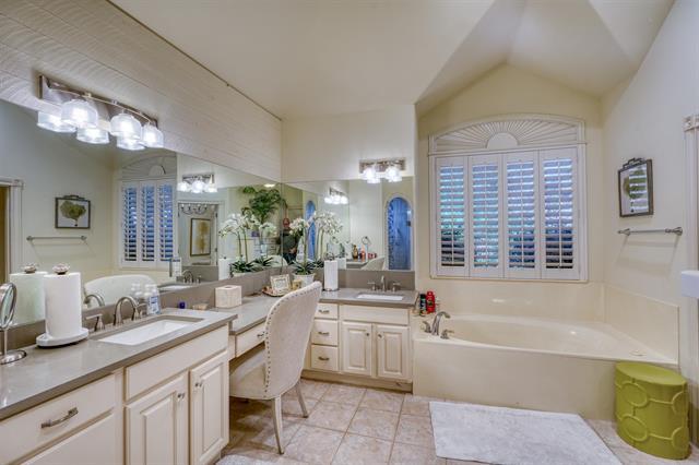 104 Mason Ct, Horseshoe Bay, TX 78657 - bathroom featuring tile patterned flooring, a garden tub, vanity, and vaulted ceiling