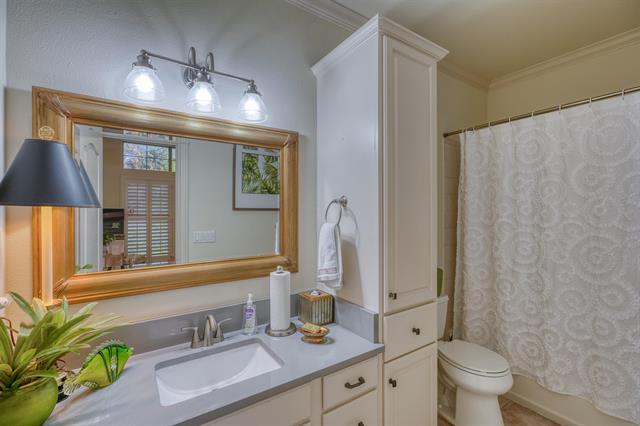 104 Mason Ct, Horseshoe Bay, TX 78657 - bathroom with vanity, toilet, crown molding, and shower / bath combination with curtain