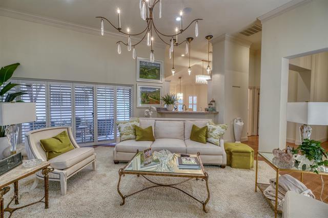 104 Mason Ct, Horseshoe Bay, TX 78657 - carpeted living room featuring crown molding, a chandelier, and a high ceiling
