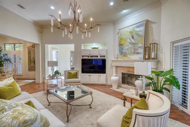 104 Mason Ct, Horseshoe Bay, TX 78657 - living room featuring crown molding, a chandelier, a premium fireplace, wood finished floors, and recessed lighting