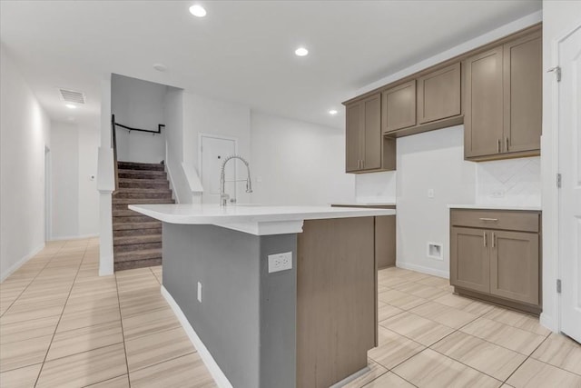 308 Castlefields St, Hutto, TX 78634 - kitchen with light tile patterned floors, an island with sink, recessed lighting, and light countertops