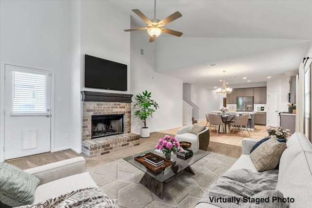 308 Castlefields St, Hutto, TX 78634 - living area with high vaulted ceiling, a chandelier, a ceiling fan, recessed lighting, and a brick fireplace
