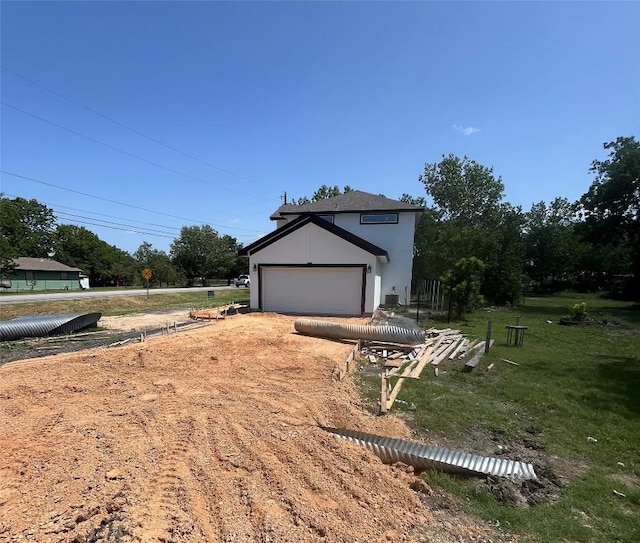 401 E Carrie St, Manor, TX 78653 - view of side of property with driveway, a yard, and stucco siding