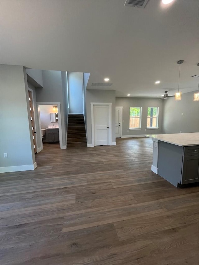 401 E Carrie St, Manor, TX 78653 - unfurnished living room featuring dark wood finished floors, recessed lighting, and stairs