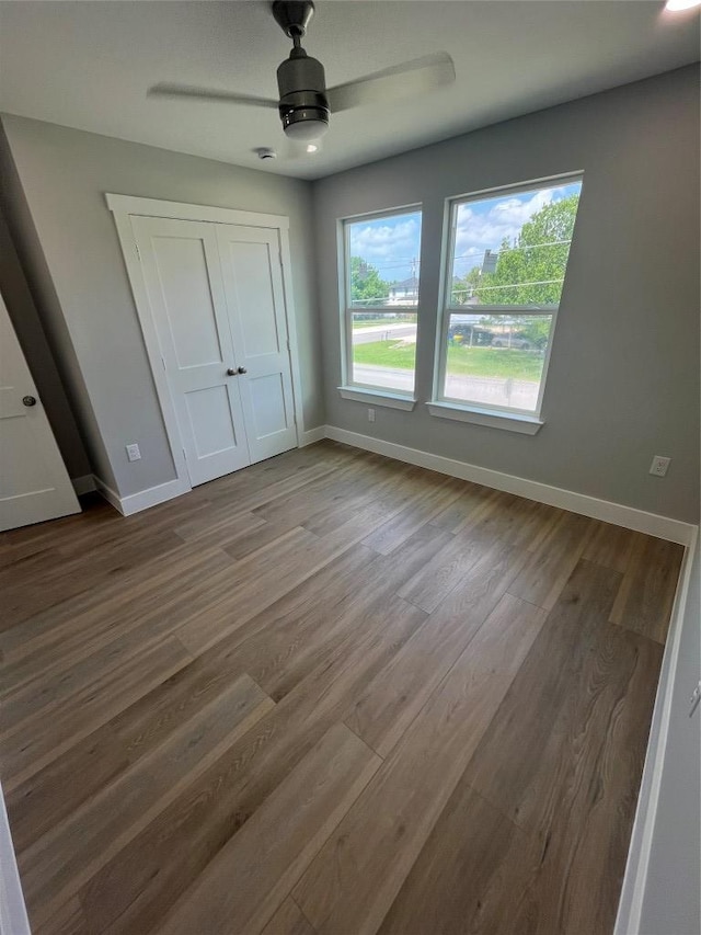 401 E Carrie St, Manor, TX 78653 - unfurnished bedroom featuring wood finished floors, a closet, and ceiling fan