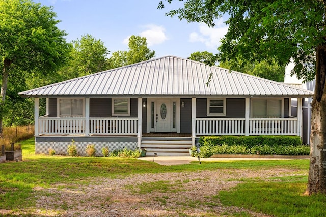 235 El Camino River Rd, Bastrop, TX 78602 - view of front of home with a metal roof, covered porch, and a front yard