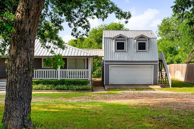 235 El Camino River Rd, Bastrop, TX 78602 - view of front of property featuring stairway, dirt driveway, a metal roof, an attached garage, and a gambrel roof