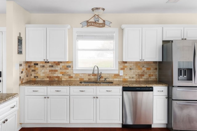 235 El Camino River Rd, Bastrop, TX 78602 - kitchen featuring stainless steel appliances, white cabinets, backsplash, and light stone counters