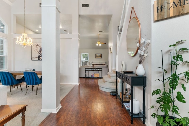 16803 Black Kettle Dr, Leander, TX 78641 - hallway with a high ceiling, a chandelier, wood finished floors, and ornate columns
