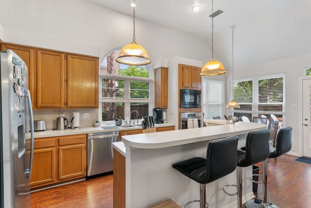 16803 Black Kettle Dr, Leander, TX 78641 - kitchen with stainless steel appliances, wood finished floors, light countertops, tasteful backsplash, and healthy amount of natural light