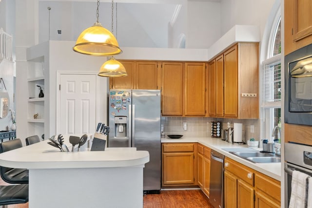 16803 Black Kettle Dr, Leander, TX 78641 - kitchen featuring appliances with stainless steel finishes, a towering ceiling, light countertops, a breakfast bar area, and dark wood-type flooring