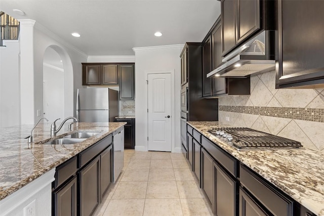 8508 Lookout Cliff Pass, Austin, TX 78737 - kitchen with stainless steel appliances, under cabinet range hood, a sink, light stone counters, and arched walkways