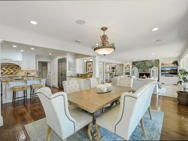 14753 Arrowhead Dr, Austin, TX 78641 - dining room with recessed lighting, dark wood-style floors, decorative columns, and a fireplace