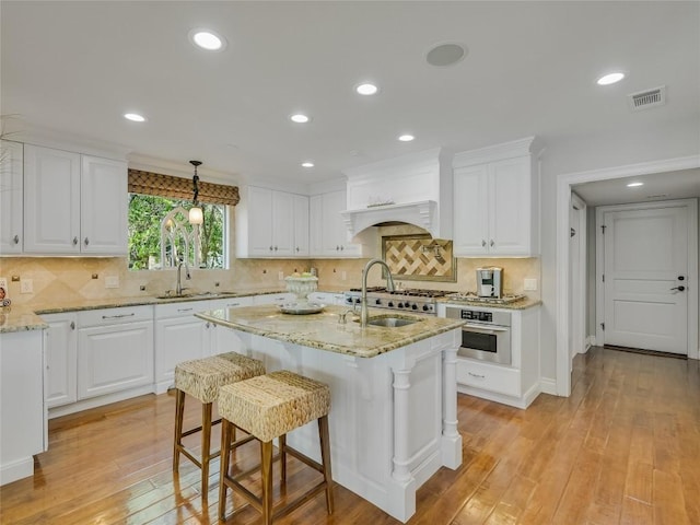 14753 Arrowhead Dr, Austin, TX 78641 - kitchen featuring white cabinetry, stainless steel oven, a sink, light stone countertops, and recessed lighting
