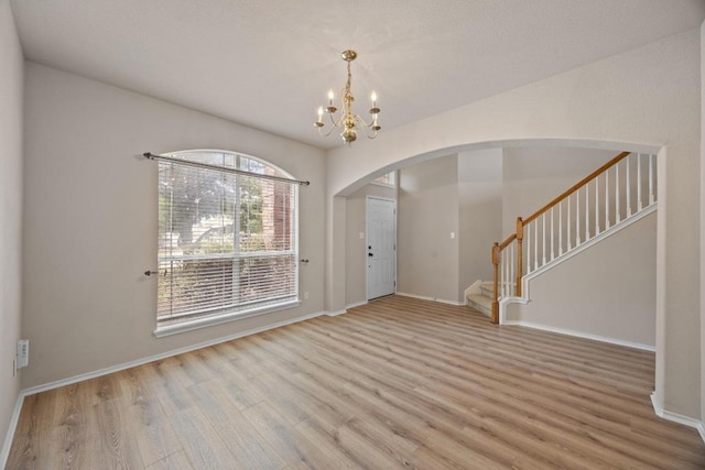 18508 Silent Water Way, Pflugerville, TX 78660 - foyer entrance featuring wood finished floors, stairway, a chandelier, arched walkways, and baseboards