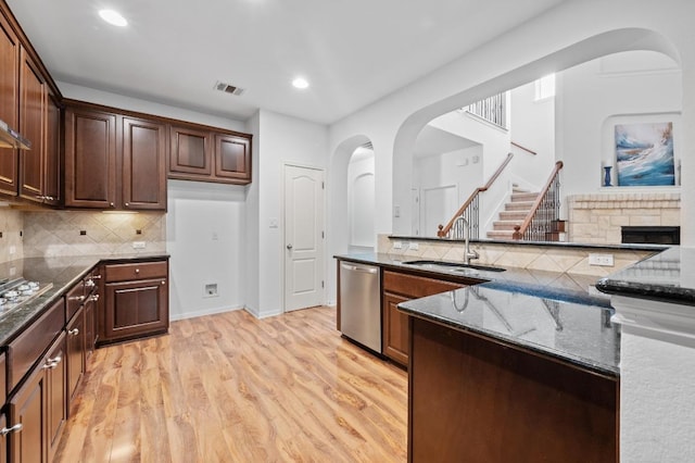 8328 Alophia Dr, Austin, TX 78739 - kitchen with appliances with stainless steel finishes, a sink, arched walkways, dark stone countertops, and recessed lighting