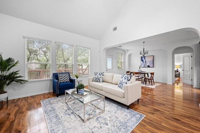 8328 Alophia Dr, Austin, TX 78739 - living area featuring arched walkways, wood finished floors, a chandelier, and high vaulted ceiling