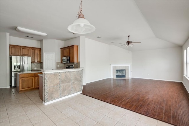 728 Stokesay Castle Path, Pflugerville, TX 78660 - kitchen with appliances with stainless steel finishes, light countertops, a ceiling fan, light tile patterned floors, and brown cabinets