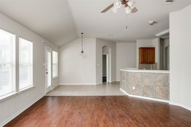 728 Stokesay Castle Path, Pflugerville, TX 78660 - unfurnished living room featuring arched walkways, light wood-style flooring, ceiling fan, and lofted ceiling