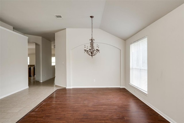 728 Stokesay Castle Path, Pflugerville, TX 78660 - spare room featuring arched walkways, plenty of natural light, a chandelier, lofted ceiling, and wood finished floors