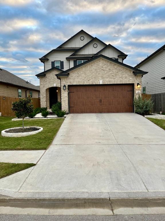 14217 Silver Lace Ln, Pflugerville, TX 78660 - view of front of home featuring a garage, concrete driveway, and stone siding