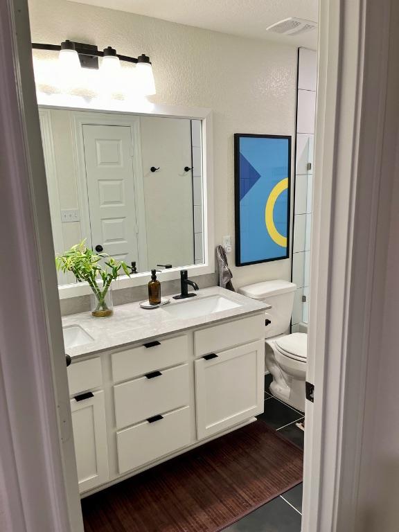 14217 Silver Lace Ln, Pflugerville, TX 78660 - bathroom with double vanity, a textured wall, and tile patterned flooring