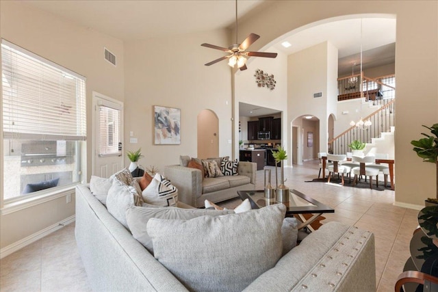 1366 Red Stag Pl, Round Rock, TX 78665 - living area with arched walkways, light tile patterned floors, healthy amount of natural light, high vaulted ceiling, and stairs