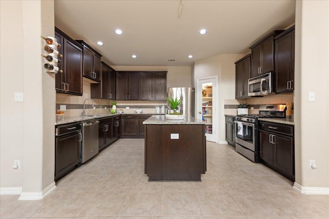 1366 Red Stag Pl, Round Rock, TX 78665 - kitchen featuring stainless steel appliances, a center island, dark brown cabinets, tasteful backsplash, and recessed lighting