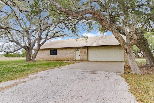 8319 County Road 200, Burnet, TX 78611 - view of front facade with gravel driveway, brick siding, an attached garage, a front lawn, and metal roof