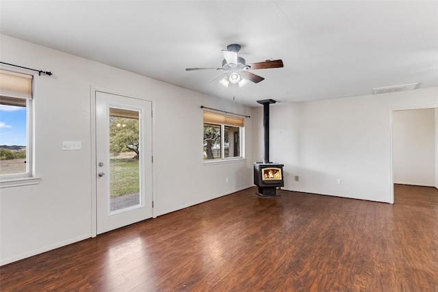 8319 County Road 200, Burnet, TX 78611 - unfurnished living room with a wood stove, wood finished floors, and ceiling fan