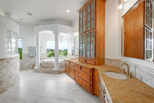 144 Serene St, Spring Branch, TX 78070 - bathroom featuring ornate columns, a garden tub, plenty of natural light, double vanity, and wainscoting