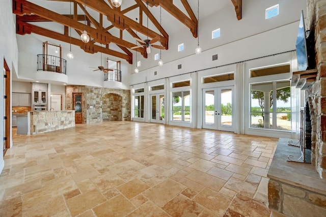 144 Serene St, Spring Branch, TX 78070 - unfurnished living room with a fireplace, high vaulted ceiling, a ceiling fan, stone tile floors, and french doors