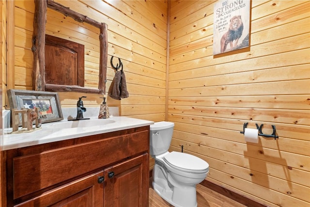 2951 County Road 360, Bartlett, TX 76511 - half bath featuring vanity, wooden walls, toilet, and wood finished floors