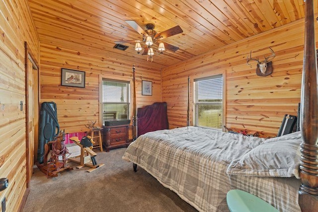 2951 County Road 360, Bartlett, TX 76511 - bedroom featuring multiple windows, carpet, wood walls, ceiling fan, and wooden ceiling