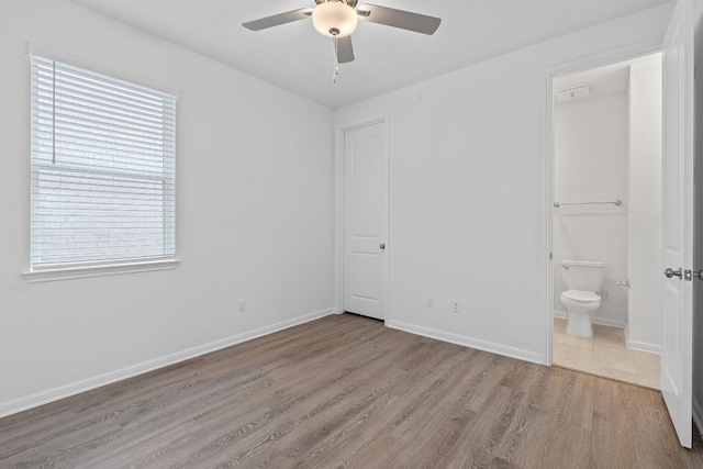 529 Leeward Pass, Leander, TX 78641 - unfurnished bedroom featuring wood finished floors, ensuite bathroom, and ceiling fan