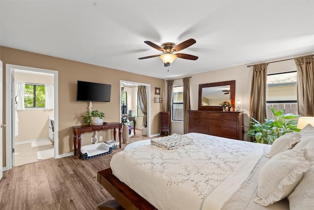 3912 Capistrano Trl, Austin, TX 78739 - bedroom featuring ensuite bath, baseboards, wood finished floors, and a ceiling fan