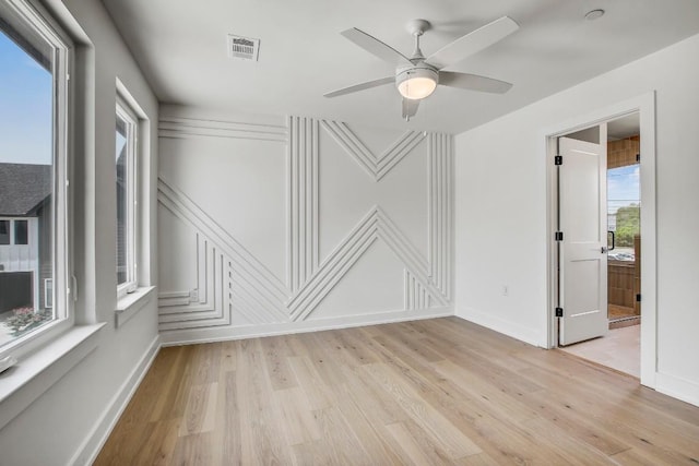 4127 E 12th St Unit 5, Austin, TX 78721 - unfurnished room featuring light wood-style floors, a decorative wall, and a ceiling fan