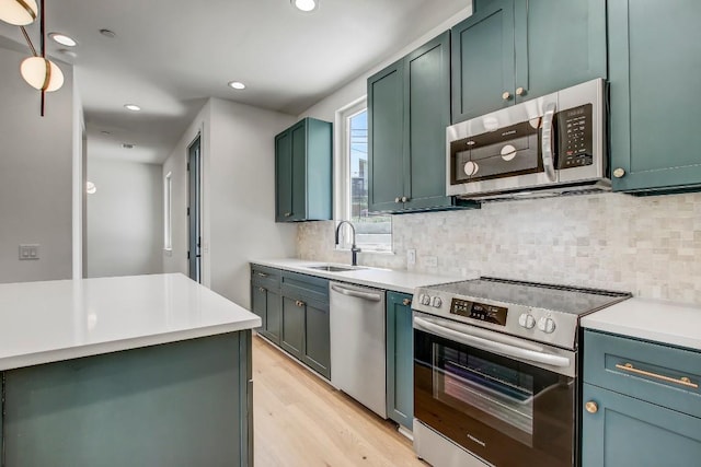 4127 E 12th St Unit 5, Austin, TX 78721 - kitchen with stainless steel appliances, light wood-style flooring, tasteful backsplash, recessed lighting, and light countertops