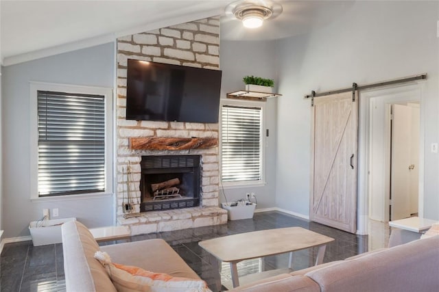 121 Kaelepulu Dr, Bastrop, TX 78602 - living area featuring lofted ceiling, a barn door, a stone fireplace, and a ceiling fan