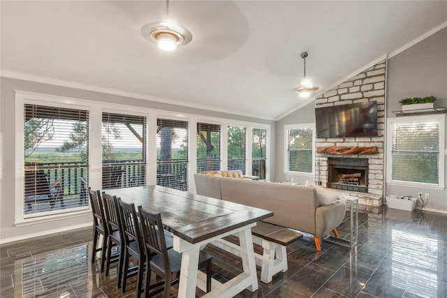 121 Kaelepulu Dr, Bastrop, TX 78602 - dining area with crown molding, lofted ceiling, plenty of natural light, and a stone fireplace