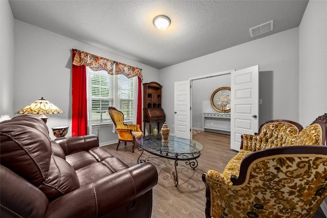 12705 Twisted Root Dr, Manchaca, TX 78652 - living area featuring wood finished floors and a textured ceiling