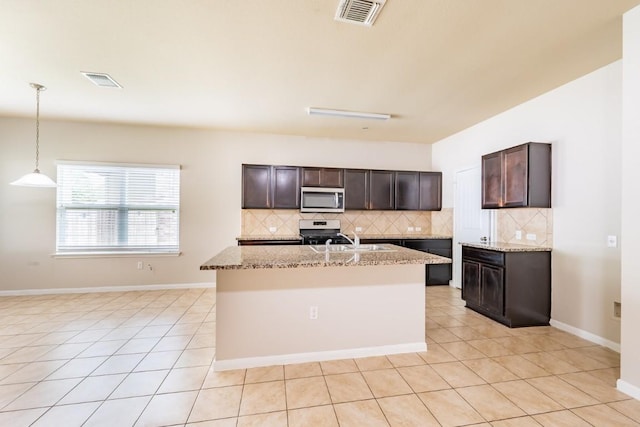 1605 Atlas Rd, Cedar Park, TX 78613 - kitchen featuring stainless steel microwave, stove, tasteful backsplash, and dark brown cabinets