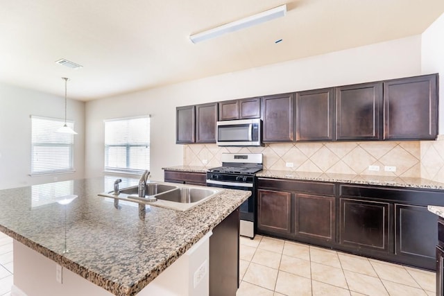 1605 Atlas Rd, Cedar Park, TX 78613 - kitchen featuring appliances with stainless steel finishes, a sink, decorative backsplash, dark brown cabinetry, and decorative light fixtures
