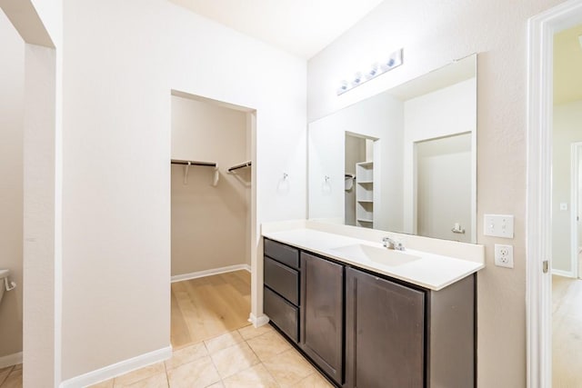 1605 Atlas Rd, Cedar Park, TX 78613 - bathroom featuring vanity, a walk in closet, baseboards, and tile patterned floors