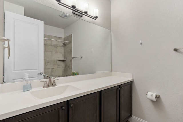 609 Glacial Stream Ln, Cedar Park, TX 78613 - bathroom with vanity, tiled shower, and baseboards