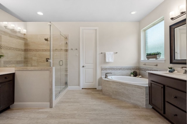 609 Glacial Stream Ln, Cedar Park, TX 78613 - bathroom with vanity, a garden tub, a stall shower, baseboards, and recessed lighting