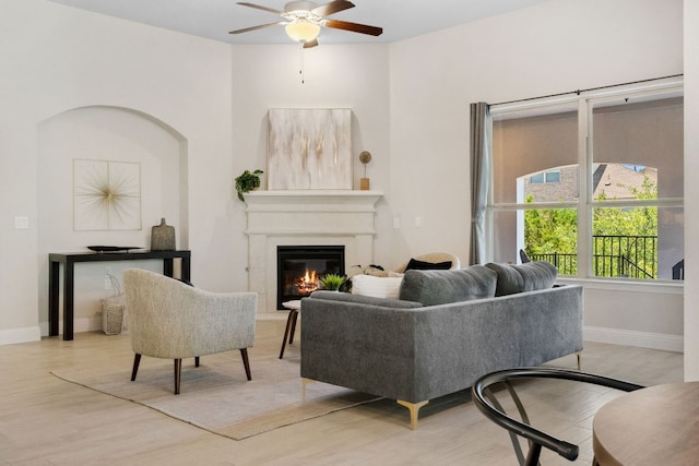 609 Glacial Stream Ln, Cedar Park, TX 78613 - living area with ceiling fan, a glass covered fireplace, baseboards, and light wood-style floors