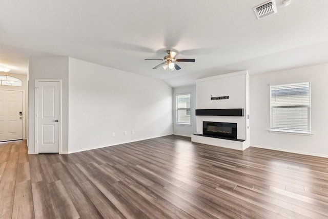133 Nathaniel Dr, Taylor, TX 76574 - unfurnished living room with ceiling fan, a glass covered fireplace, and wood finished floors