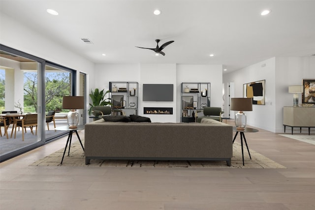 201 Custers Last Stand, Horseshoe Bay, TX 78657 - living area featuring recessed lighting, wood finished floors, a lit fireplace, and ceiling fan